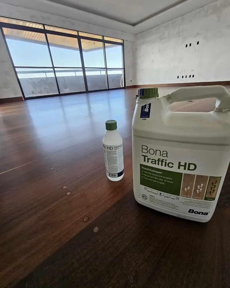 Assoalho escuro com acabamento Bona Traffic HD fosco e o galão do produto em primeiro plano