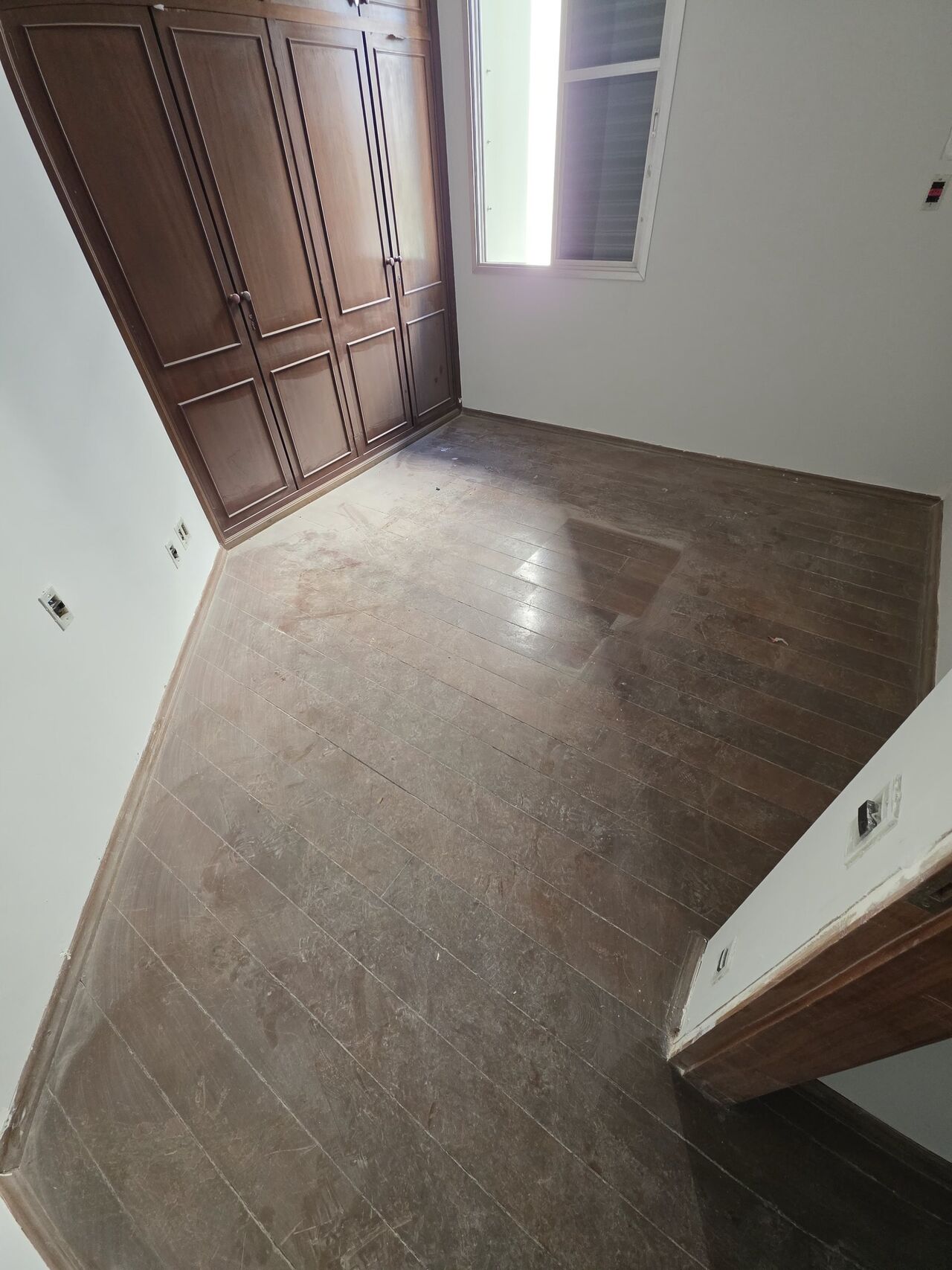 Quarto com assoalho opaco e manchado, antes da restauração