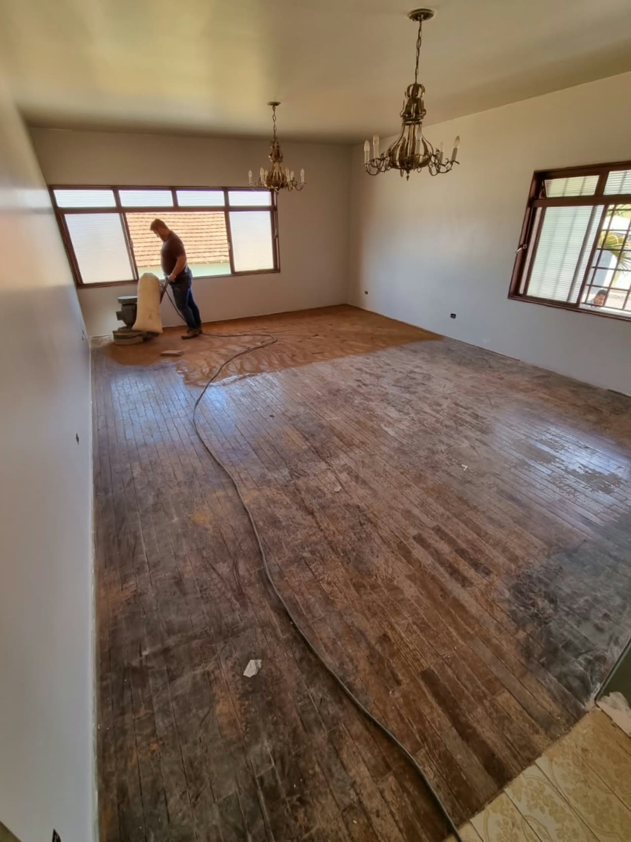 Sala com taco de ipê opaco e marcado, no começo da obra