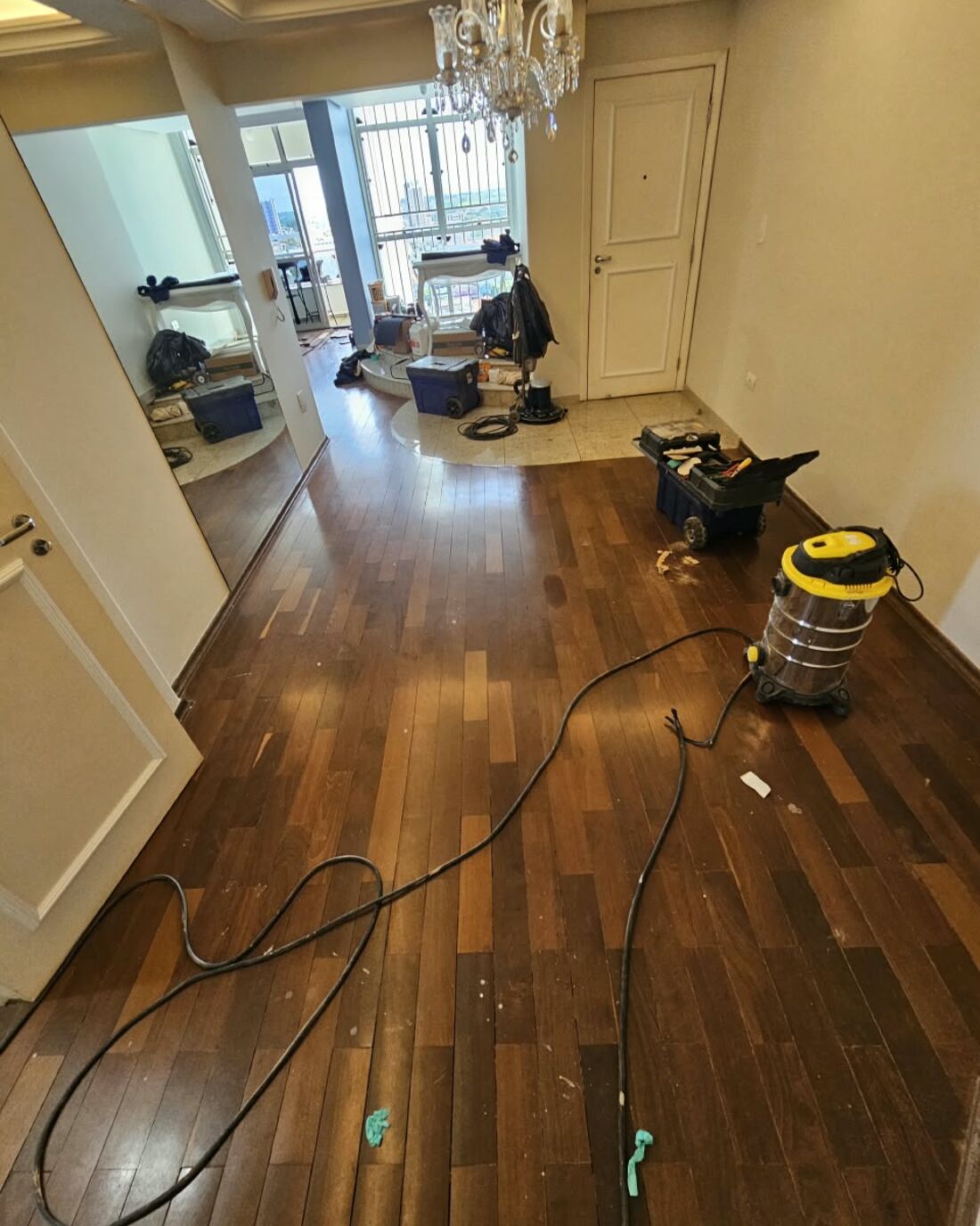Obra em andamento com aspirador e cabos protegidos no piso