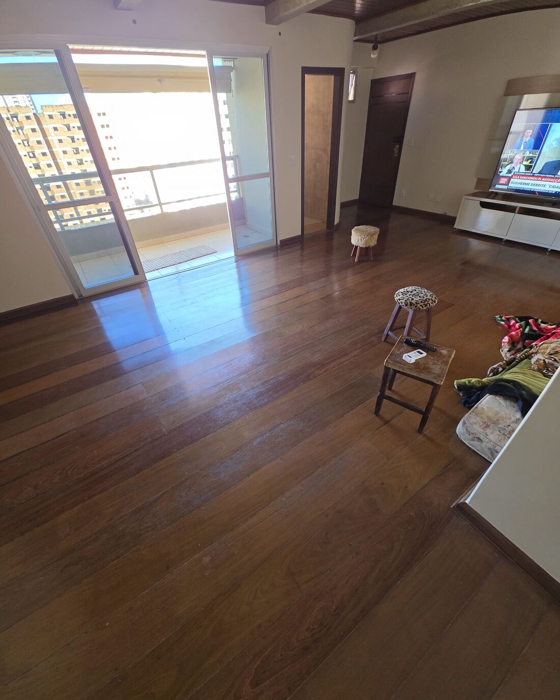 Sala com assoalho maciço instalado e porta para a sacada