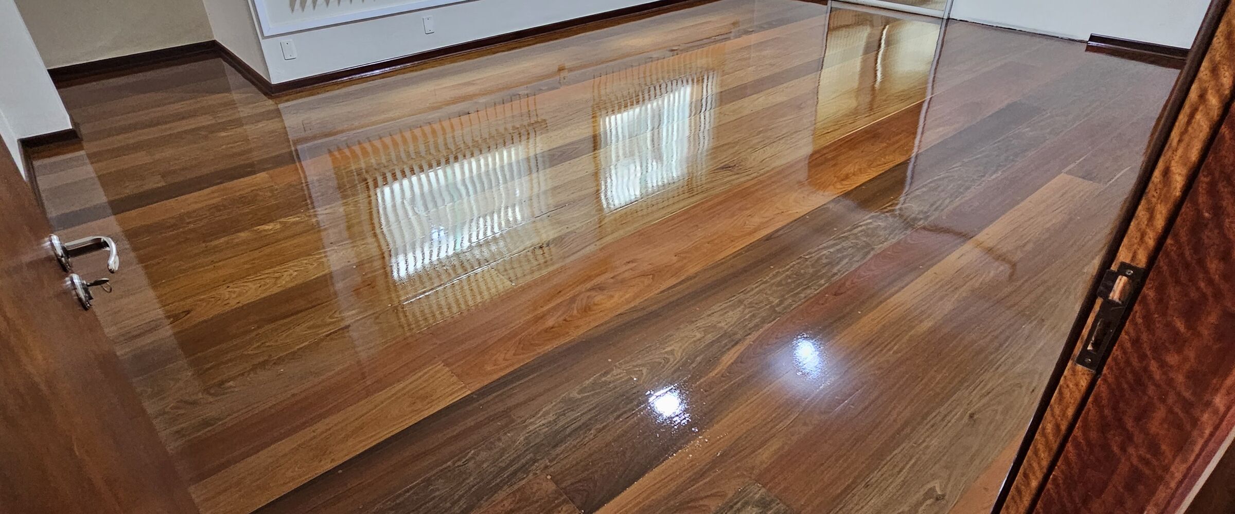 Assoalho maciço com reflexo das janelas no verniz