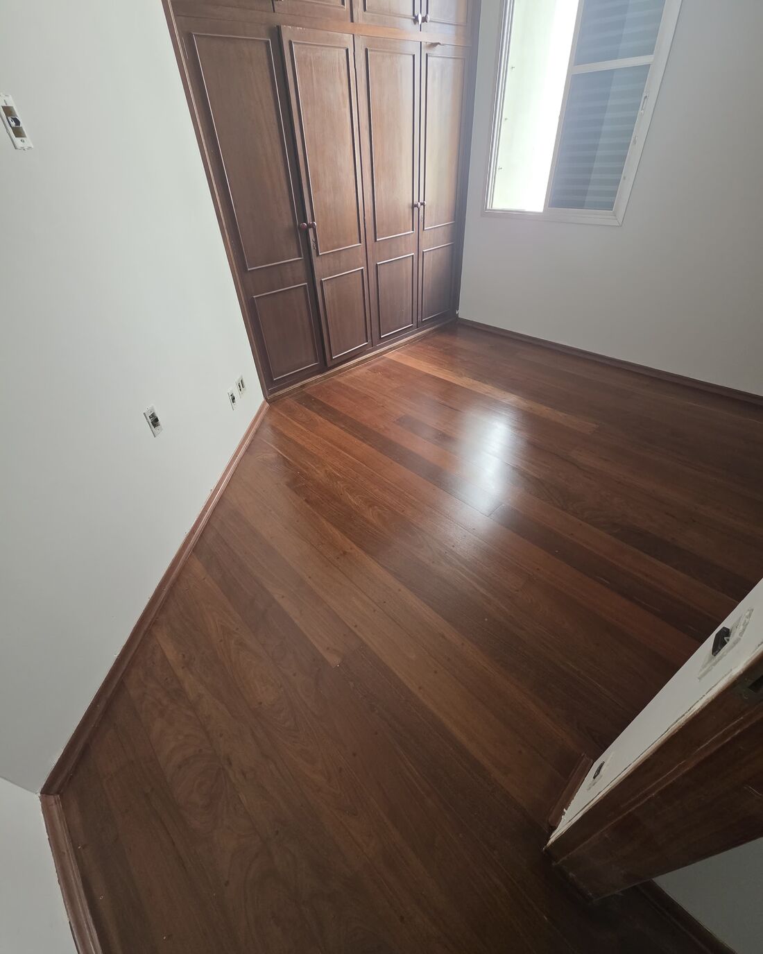 Assoalho de tábua corrida instalado e envernizado em quarto