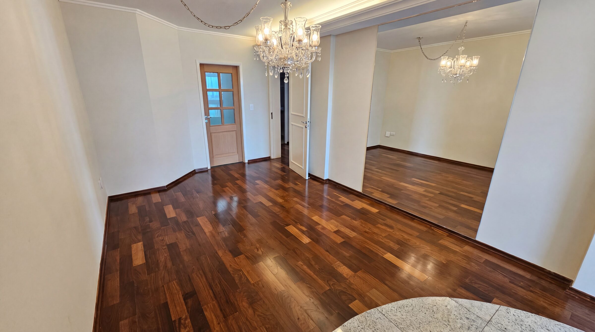 Sala com lustres de cristal e piso de tábuas de madeira restaurado em alto brilho