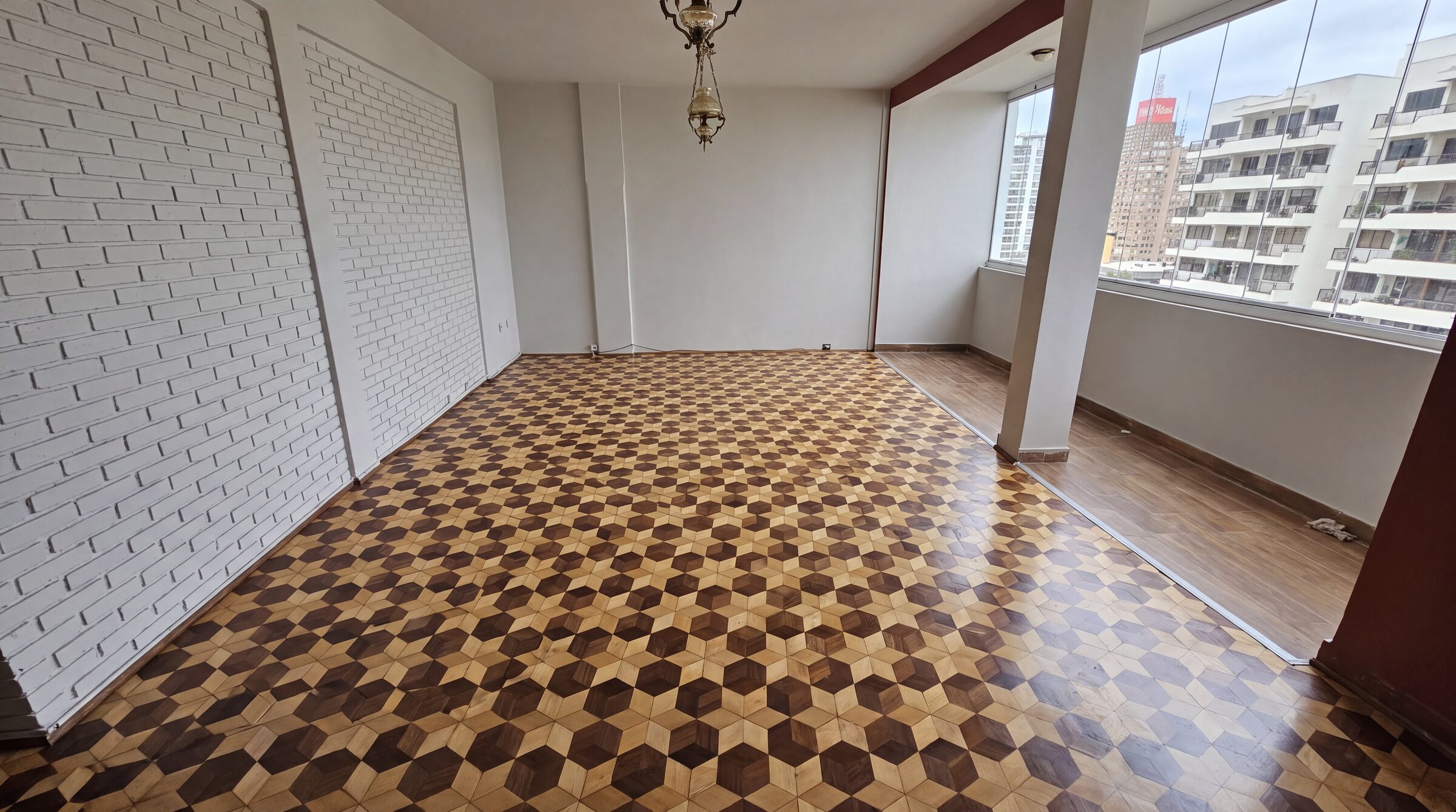 Sala com taco instalado em padrão geométrico de estrelas e hexágonos em dois tons de madeira